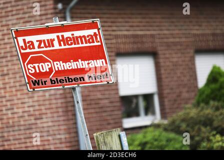 08 ottobre 2020, Renania Settentrionale-Vestfalia, Erkelenz: Un segno di protesta con l'iscrizione 'Ja zur Heimat - Wir bleibern hier' ('Sì a casa - noi rimaniamo qui') si trova di fronte ad una casa abbandonata nel villaggio di Berverath vicino Erkelenz. Il controverso reinsediamento di cinque villaggi nella zona mineraria renish della lignite deve continuare. Ciò è previsto in una nuova decisione di leadership elaborata dal gabinetto. Secondo esso, il reinsediamento dei cinque villaggi di Erkelenz Keyenberg, Kuckum, Unter- e Oberwestrich e Berverath deve continuare 'in modo socialmente accettabile' e deve essere completato Foto Stock