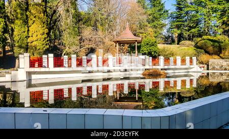 Gazebo in legno e laghetto incorniciato da pietra bianca nell'arboreto di Sochi. Russia Foto Stock