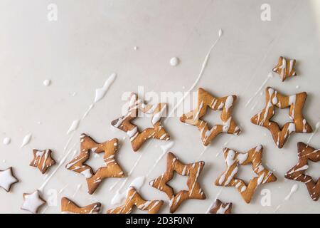 In casa stella di Natale forma lo zucchero caramellato i biscotti con la glassa bianca su sfondo marmo. Laici piana, copia dello spazio. Dolce di Natale o Capodanno dono. Foto Stock
