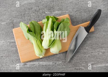 bok choy cavolo e coltello sul tagliere Foto Stock