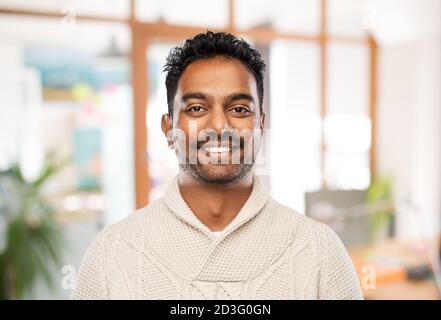 indiano uomo in maglione su sfondo ufficio Foto Stock