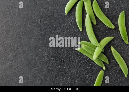 piselli su fondo di pietra ardesia bagnato Foto Stock