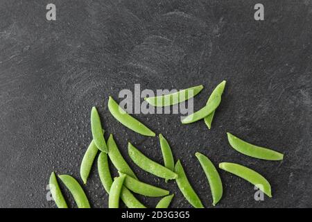 piselli su fondo di pietra ardesia bagnato Foto Stock