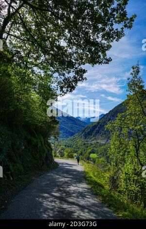 Solitario camminatore femminile sopra il villaggio di Niaux nella Valle di Vicdessos, nell'Ariege, Pirenei francesi, Francia, tempo di autunno. Foto Stock