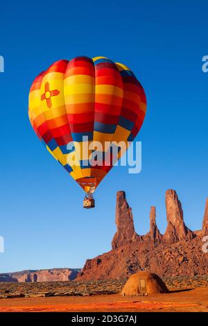 Mongolfiera che sorge sopra le tre Sorelle, Monument Valley Tribal Park, Arizona Foto Stock