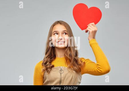 Sorridente ragazza adolescente con cuore rosso Foto Stock