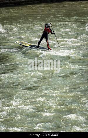 Uomo sul suo Stand up Paddleboarding (SUP), pagaia nelle rapide del fiume Adige nel centro di Verona. Veneto, Italia, Europa. Foto Stock