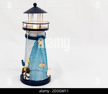Un piccolo blu e bianco al faro utilizzato come decorazione da tavolo con thieme nautico. Foto Stock