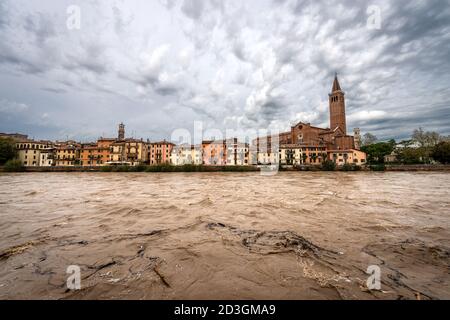 Paesaggio urbano di Verona con la chiesa di Sant'Anastasia (1290-1471) e il fiume Adige in piena dopo diverse violente tempeste. Sito patrimonio dell'umanità dell'UNESCO. Foto Stock