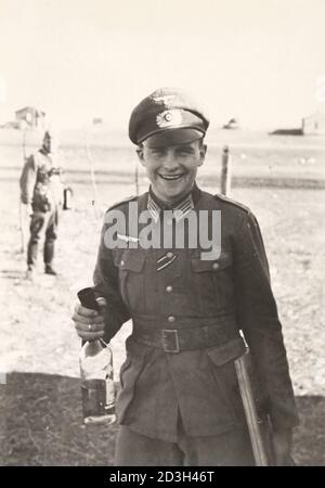 Soldato tedesco con una bottiglia di alcol durante la seconda guerra mondiale Foto Stock