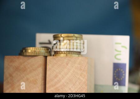 2 pile di monete in euro e 100 euro di bolletta. Il concetto di crescita del profitto aziendale Foto Stock