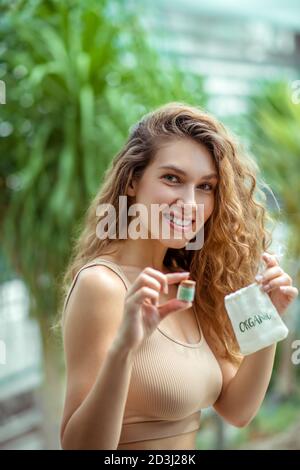 Giovane donna che tiene la scatola dell'ombretto e la borsa ecologica Foto Stock