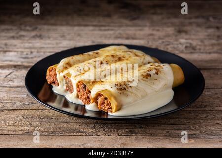 Deliziosa pasta cannelloni di carne su tavola di legno Foto Stock