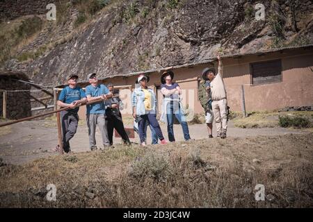 Una guida che mostra i turisti intorno Pisaq Pisac Incan sito, Perù Foto Stock