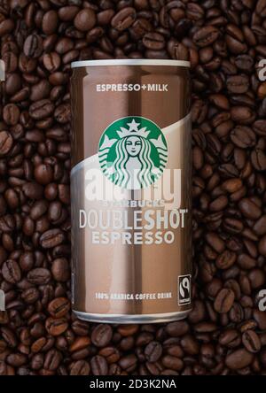 LONDRA, Regno Unito - 09 SETTEMBRE 2020: Lattina di alluminio di caffè espresso freddo espresso doppio Starbucks sopra i chicchi di caffè crudo fresco. Foto Stock