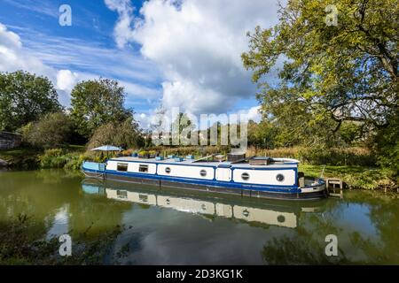 Narrowboat ormeggiato sulla riva del ramo Bruce del Kennett e Avon Canal a Great Bedwyn, un villaggio nel Wiltshire orientale, Inghilterra meridionale Foto Stock