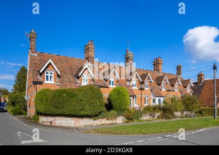 Vista di tipici cottage terrazzati in mattoni rossi e case nella principale High Street di Great Bedwyn, un villaggio nel Wiltshire orientale, Inghilterra meridionale Foto Stock