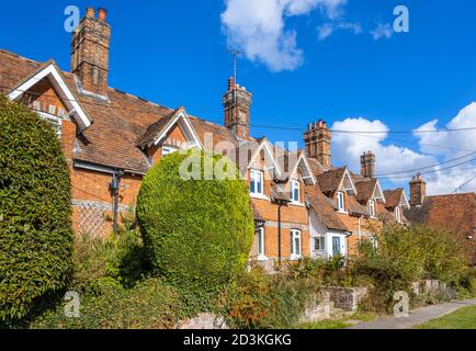 Vista di tipici cottage terrazzati in mattoni rossi e case nella principale High Street di Great Bedwyn, un villaggio nel Wiltshire orientale, Inghilterra meridionale Foto Stock