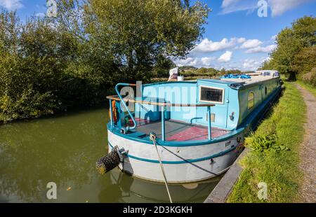 Narrowboat ormeggiato sulla riva del ramo Bruce del Kennett e Avon Canal a Great Bedwyn, un villaggio nel Wiltshire orientale, Inghilterra meridionale Foto Stock