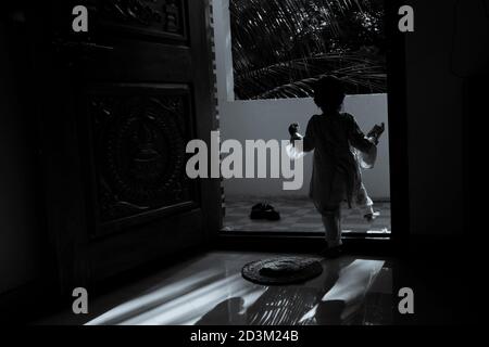Ragazza bambino silhouette in mattina luce del sole in una casa monocromatica foto, Kalaburagi, Karnataka/India-Settembre 24 2020 Foto Stock