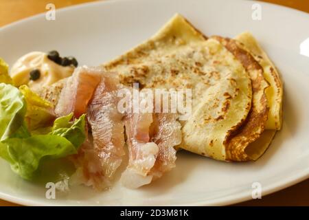 Gravlax con pancake servita foglie di insalata Foto Stock