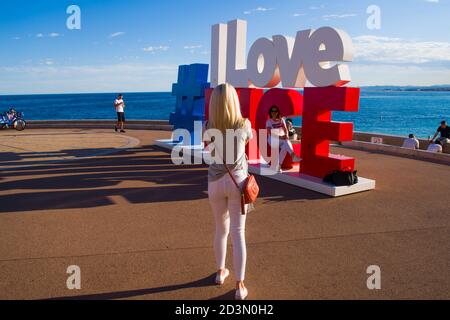 NIZZA, FRANCIA-MAGGIO,29,2019: il turista pone per una foto vicino all'installazione dei cartelli turistici i love Nice sopra Promenade des Anglais nella città di Nizza Foto Stock