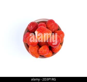 Fragole in una tazza bianca isolata su uno sfondo chiaro. Foto Stock