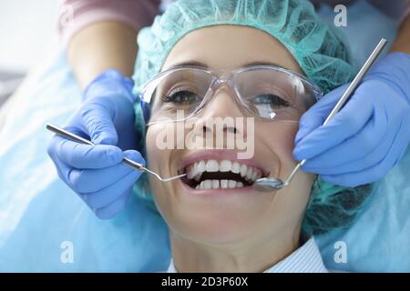 La cavità orale della donna viene esaminata presso l'ufficio del dentista Foto Stock