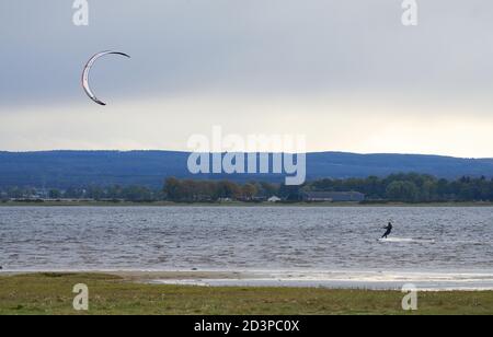 Findhorn Bay, Moray, Regno Unito. 8 Ott 2020. REGNO UNITO. Questo è un Kitesurfer in azione all'interno della baia di Findhorn durante l'alta marea in un freddo pomeriggio di ottobre con la città di Forres sullo sfondo. Credit: JASPERIMAGE/Alamy Live News Foto Stock