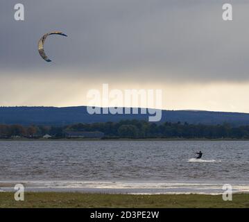 Findhorn Bay, Moray, Regno Unito. 8 Ott 2020. REGNO UNITO. Questo è un Kitesurfer in azione all'interno della baia di Findhorn durante l'alta marea in un freddo pomeriggio di ottobre con la città di Forres sullo sfondo. Credit: JASPERIMAGE/Alamy Live News Foto Stock