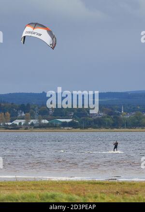 Findhorn Bay, Moray, Regno Unito. 8 Ott 2020. REGNO UNITO. Questo è un Kitesurfer in azione all'interno della baia di Findhorn durante l'alta marea in un freddo pomeriggio di ottobre con la città di Forres sullo sfondo. Credit: JASPERIMAGE/Alamy Live News Foto Stock