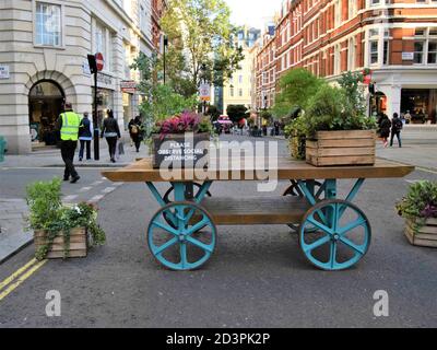 Si prega di osservare il cartello stradale Social Distancing e la barriera di limitazione del traffico a Covent Garden, Londra, 2020. Cartelli e carrelli simili sono stati collocati intorno a Covent Garden per limitare il traffico dei veicoli e facilitare le distanze sociali durante la pandemia. Foto Stock