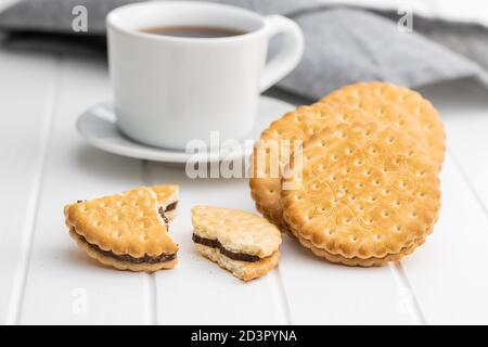 Biscotti sandwich. Biscotti dolci con panna su tavola bianca. Foto Stock