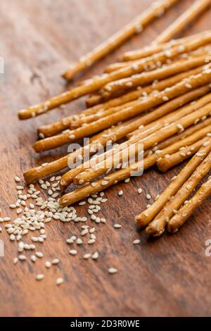 Bastoncini salati. Pretzel croccanti con semi di sesamo su tavolo di legno. Foto Stock