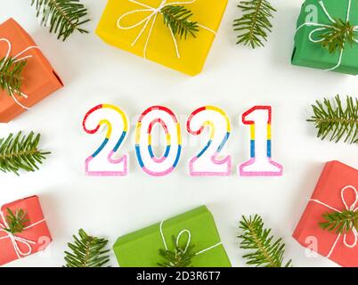 Cartolina di vacanza con rami di abete, scatole regalo e 2021 figure su sfondo bianco. Natale appartamento posa. Foto Stock