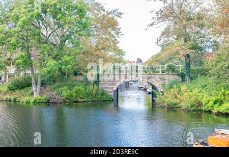 Vista pittoresca in autunno di un vecchio ponte su un canale nella città di Leiden, Olanda Foto Stock