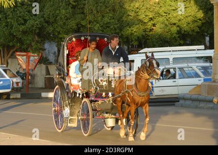 Nelle strade della città di Luxor, il ritmo della vita è calmo. Un autista di cavalli trasporta i turisti. Foto Stock