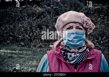 donna che indossa una maschera protettiva monouso contro il virus covid-19 Foto Stock