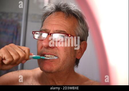 Uomo anziano in bagno con spazzola a denti Foto Stock