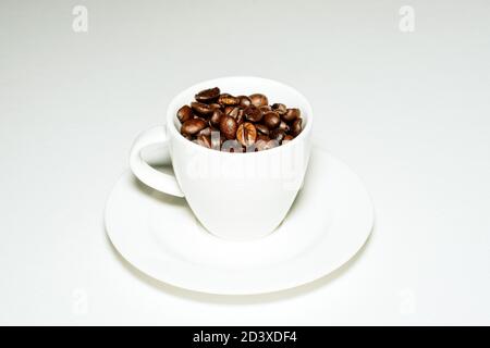 Tazza da caffè piena di chicchi di caffè Foto Stock