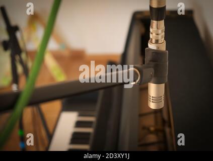 Primo piano di un microfono a soffitto che registra un pianoforte verticale. Foto Stock