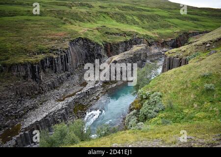 Studlagil Canyon nel nord-est dell'Islanda. Il fiume Jokla attraversa le colonne di basalto esagonali. Il terreno in pendenza finisce bruscamente creando il canyon. Foto Stock