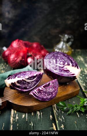 Primo piano affettato e mezzo di cavolo viola sopra sfondo rustico Foto Stock