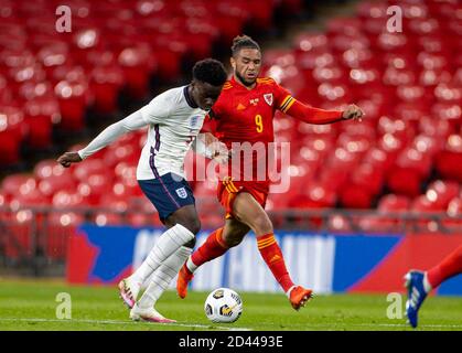 Londra, Regno Unito. 9 Ott 2020. Il Wales' Tyler Roberts (R) vies con il Bukayo Saka dell'Inghilterra durante un amichevole incontro tra Inghilterra e Galles a Londra, Gran Bretagna, l'8 ottobre 2020. Credit: Xinhua/Alamy Live News Foto Stock