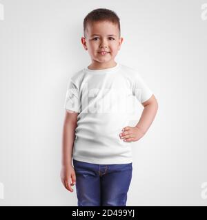 Abito alla moda modello su ragazzo in t shirt bianca e jeans blu con mano sulla cintura bambini in bianco per la presentazione di design. Abbigliamento mockup per Foto stock Alamy