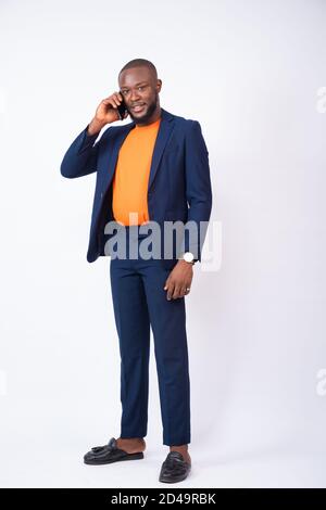 giovane uomo d'affari africano che fa una telefonata, in piedi su uno sfondo bianco Foto Stock