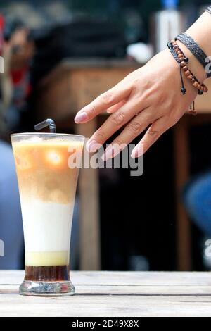 una tazza di caffè al latte ghiacciato su un tavolo da caffè in legno. per le pause caffè durante il giorno, preparate un caffè fresco Foto Stock