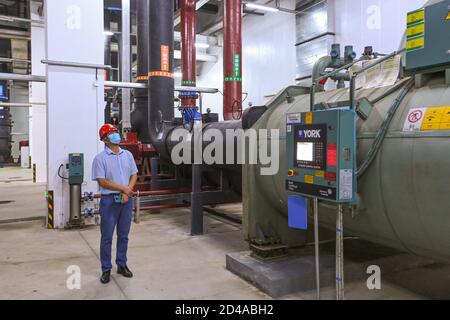 Shenzhen, la provincia cinese di Guangdong. 7 Ott 2020. Un tecnico ispeziona la stazione di raffreddamento centralizzata della metropolitana n° 10 in Cina (Guangdong) Pilot Free Trade zone Qianhai & Shekou Area a Shenzhen, nella provincia di Guangdong nella Cina meridionale, 7 ottobre 2020. Shenzhen ha costruito diverse stazioni di raffreddamento centralizzate per gli edifici adiacenti per sostituire il singolo sistema di raffreddamento come parte del suo sviluppo verde. La stazione centrale di raffreddamento N. 10 può qui fornire raffreddamento per gli edifici in un'area di circa un milione di metri quadrati intorno ad essa. Credit: Liu Dawei/Xinhua/Alamy Live News Foto Stock