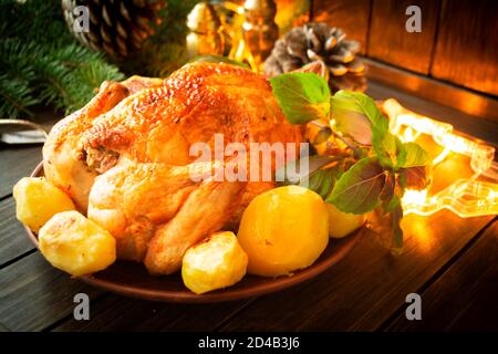 Pollo cotto in casa con limone, basilico e patate su sfondo di legno Foto Stock