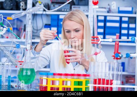 Girl Laboratory Assistant lavora con un farmaco antivirale in un laboratorio farmaceutico Foto Stock